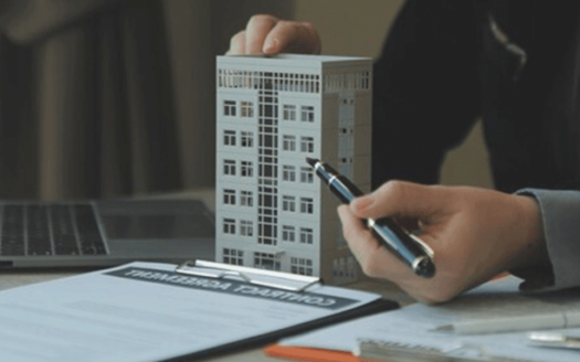 Estate agent holding a model building