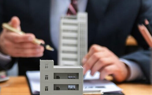 : business professionals discussing a building model at a meeting table