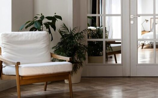 A cozy living room with a white chair and plants.
